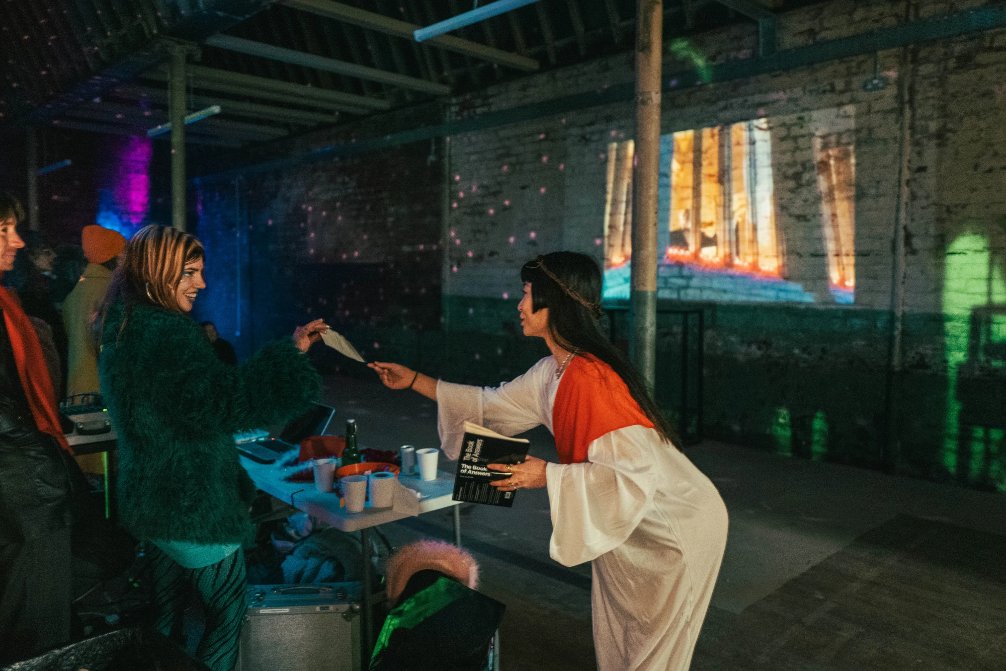 a woman dressed as jesus hands something to an audience member.