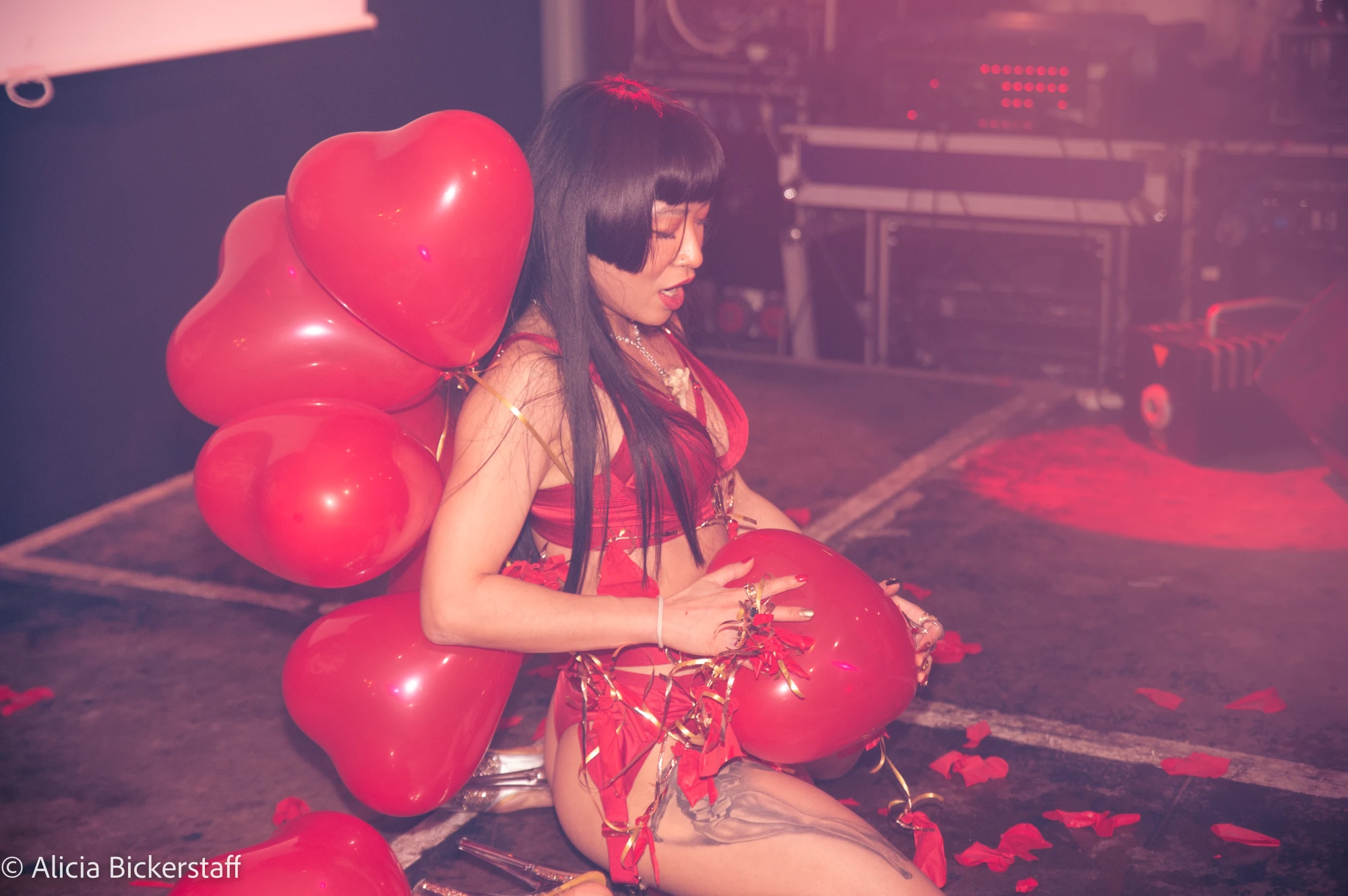 a woman is popping balloons on stage.