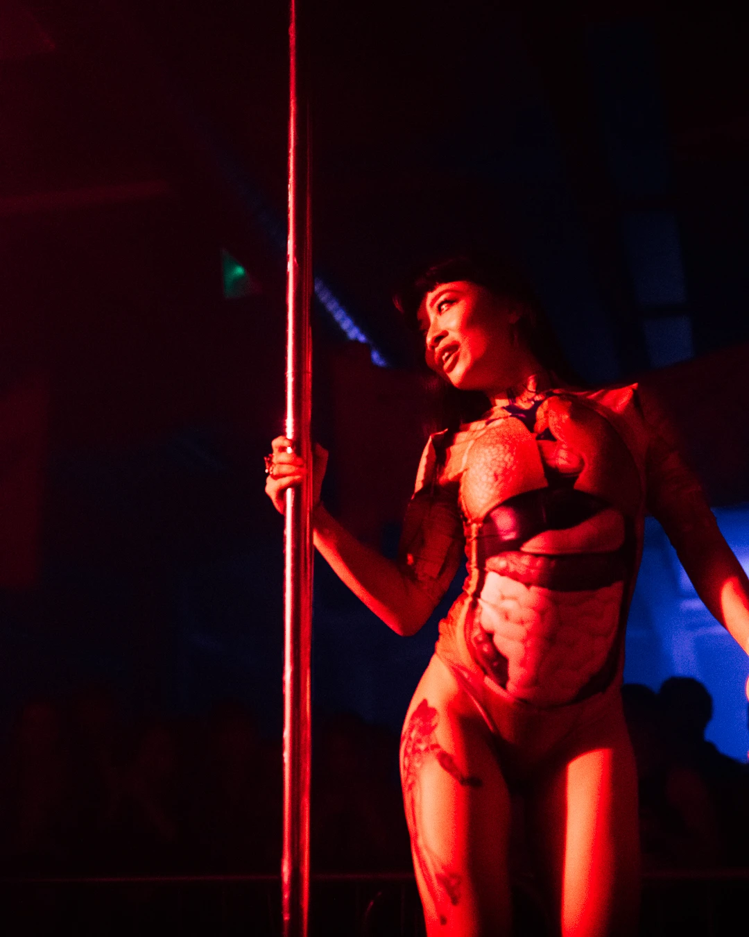 a woman wearing an internal organs bodysuit is on the pole.