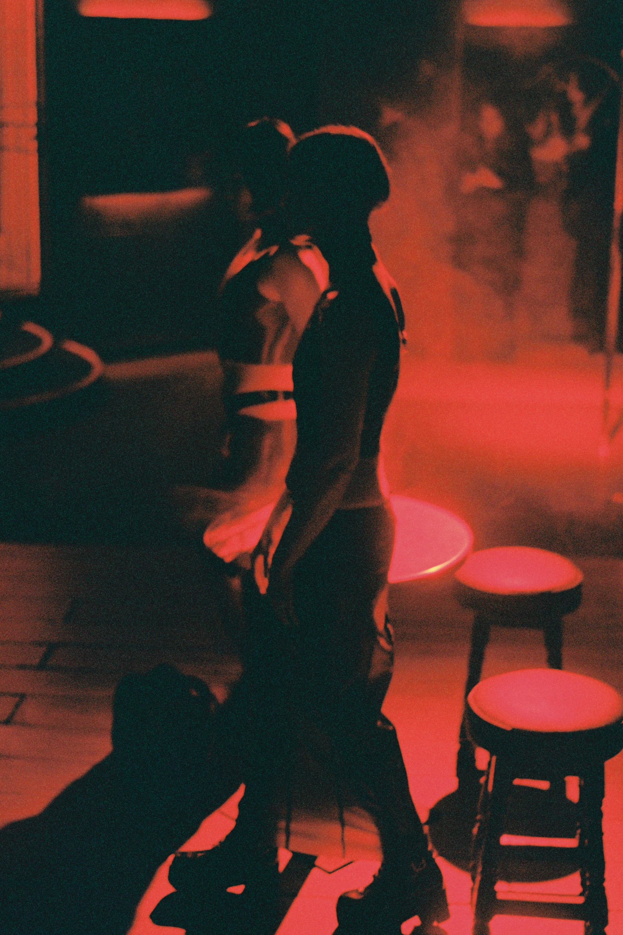 two people stand up under a red light.