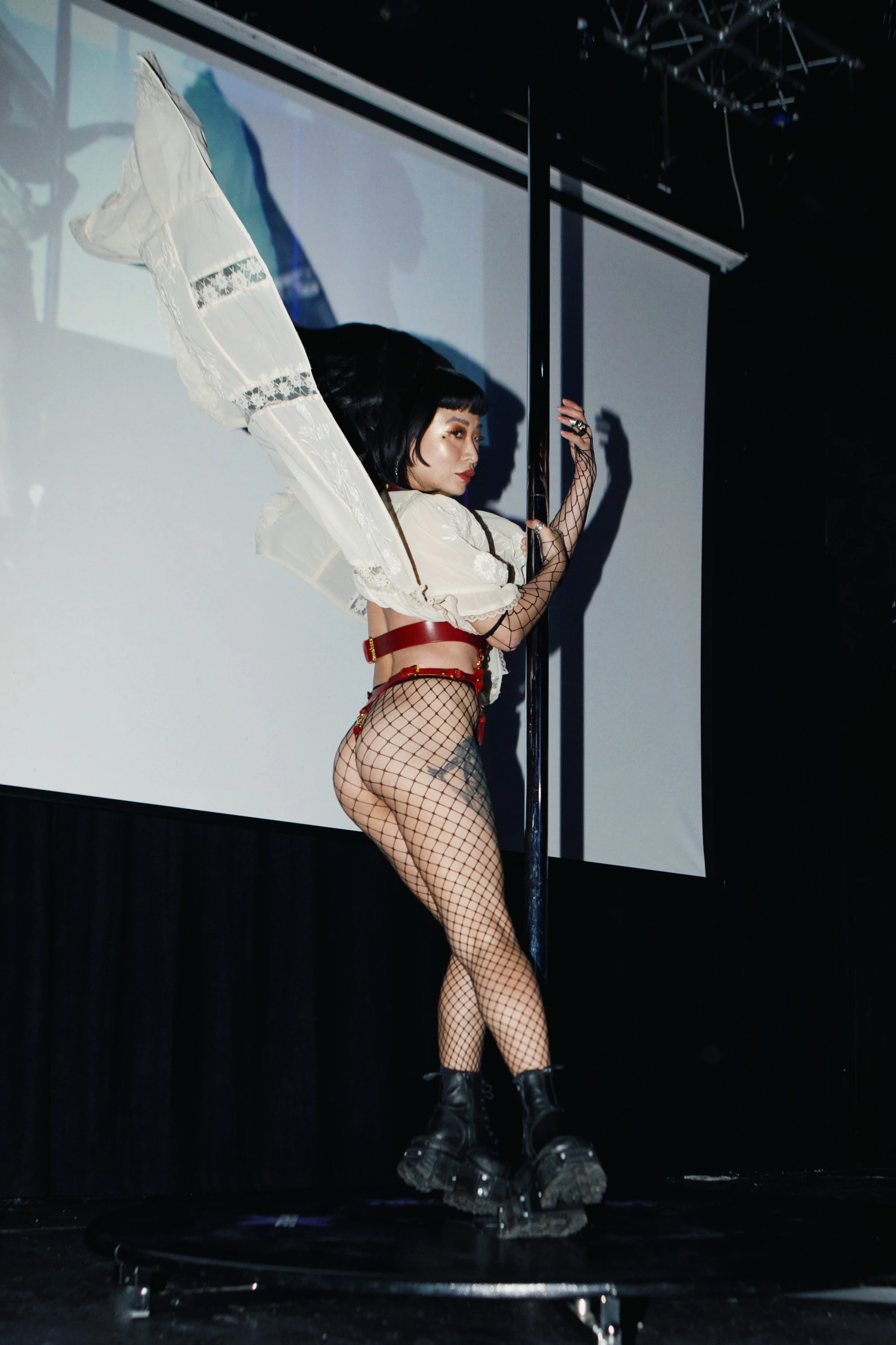 a woman with big hair is on the pole.