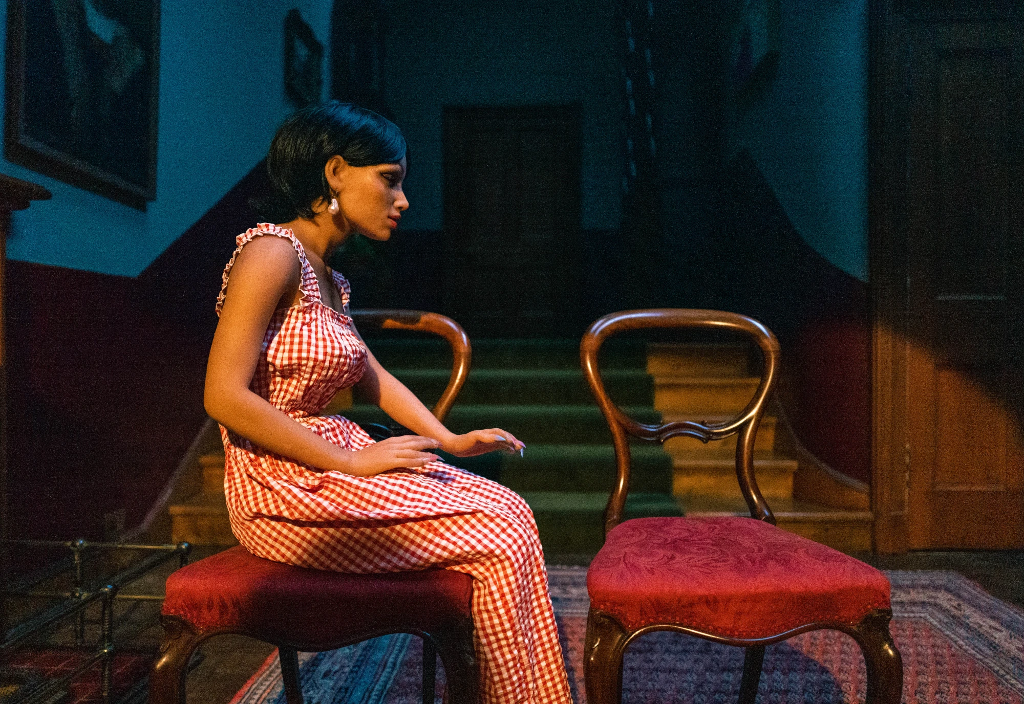 a silcone love doll sits in the hallway of a grand building.