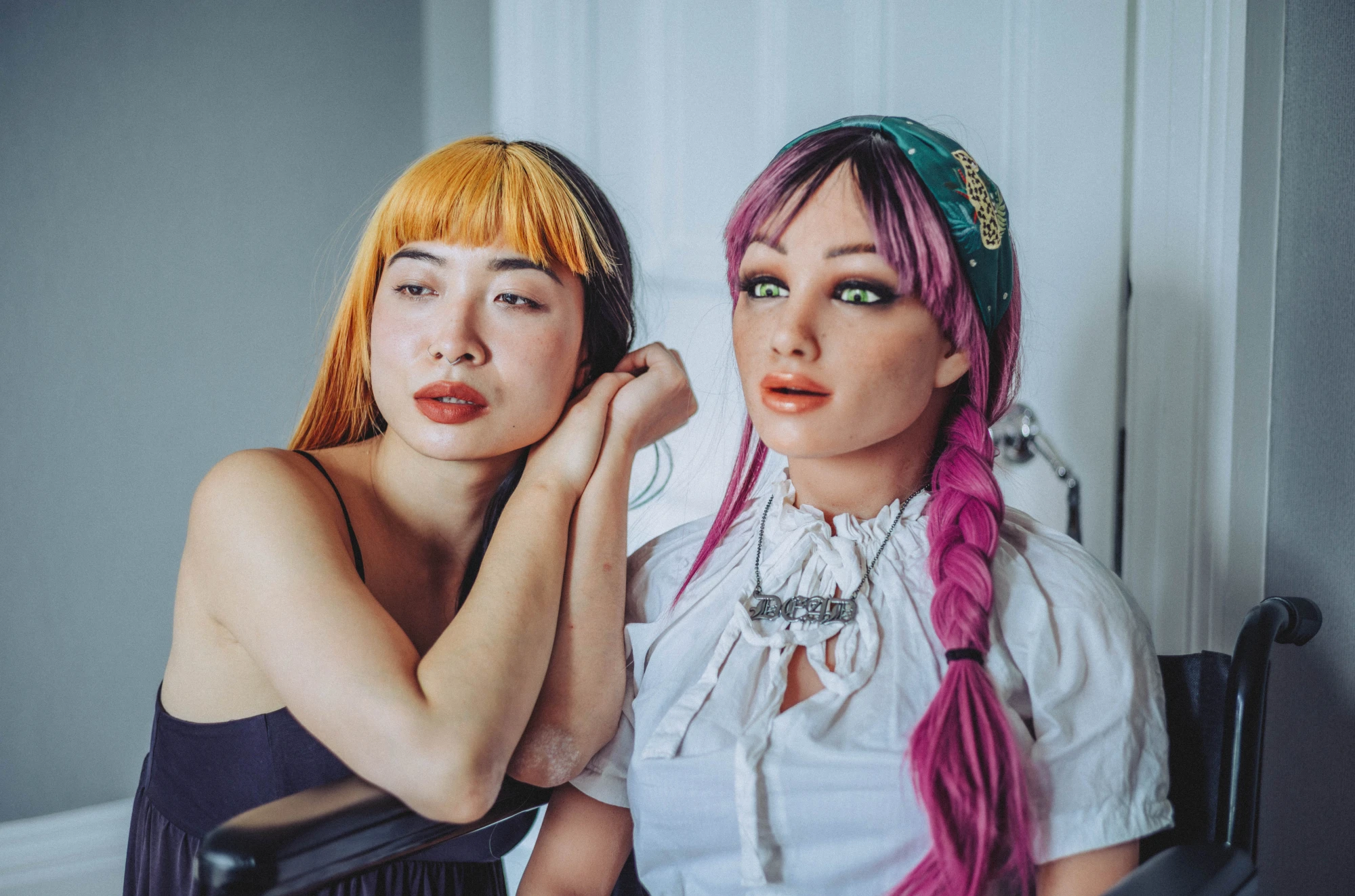 a woman and a silicone love doll next to each other.