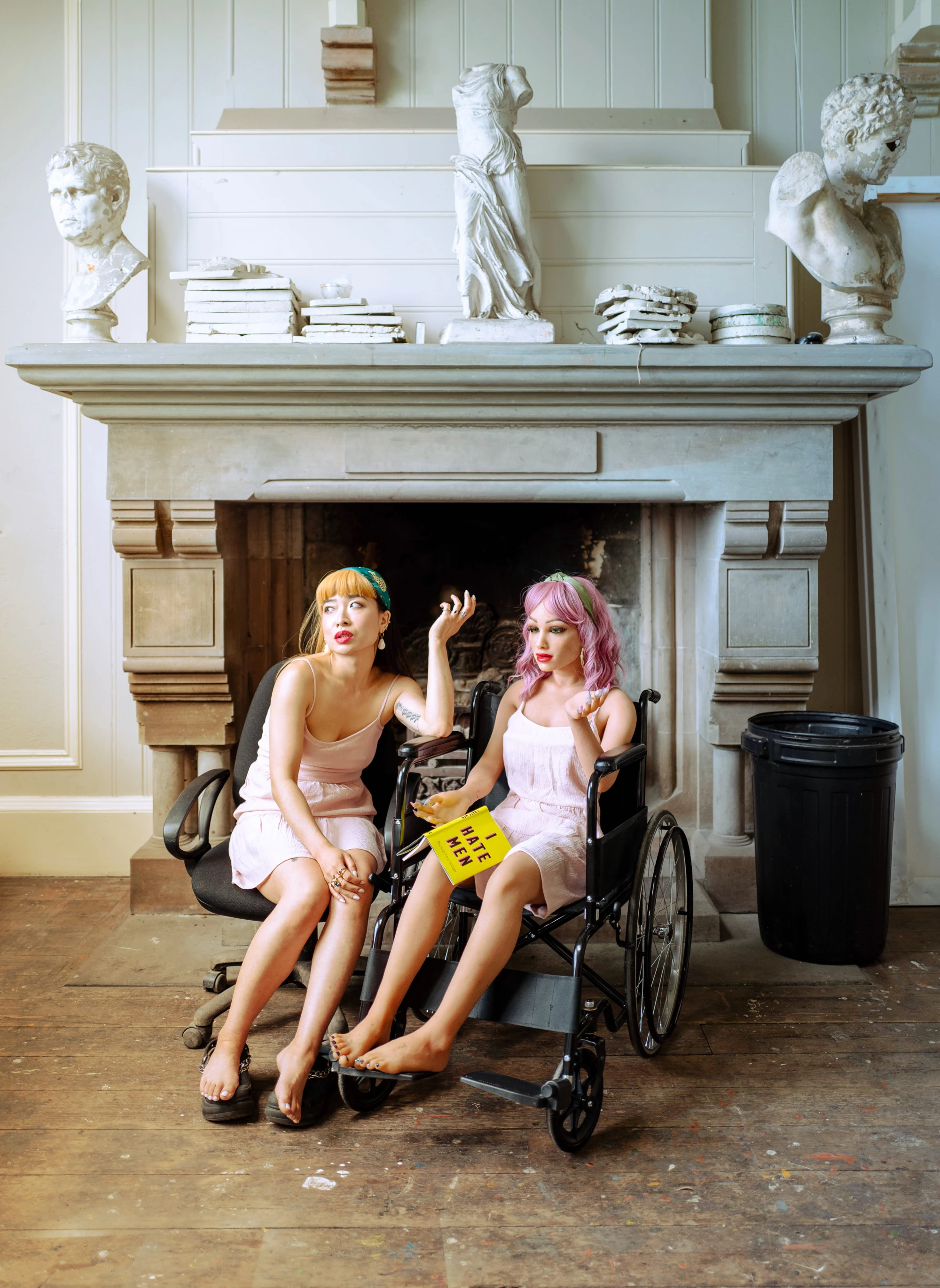 a woman and a silicone love doll is reading a book together called 'I hate men'.