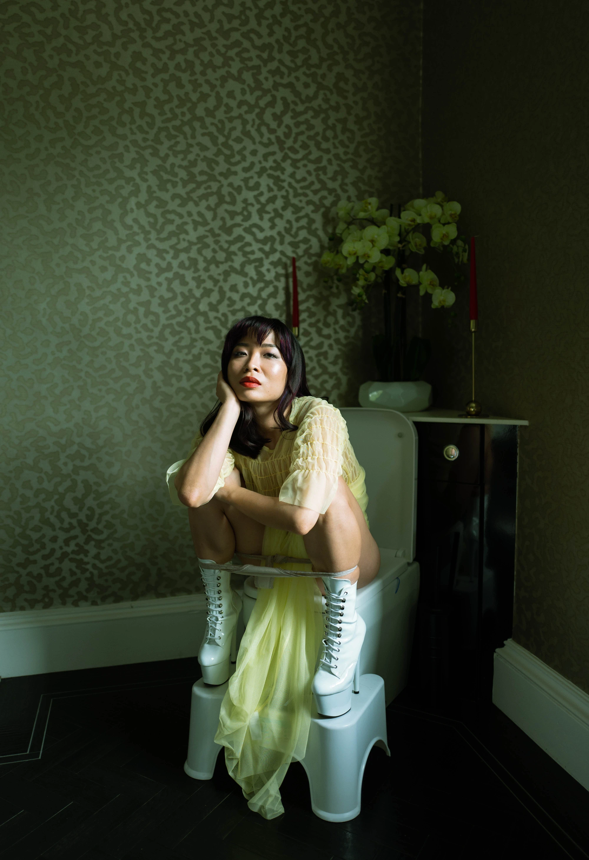 a woman on the toilet with a potty squatty.