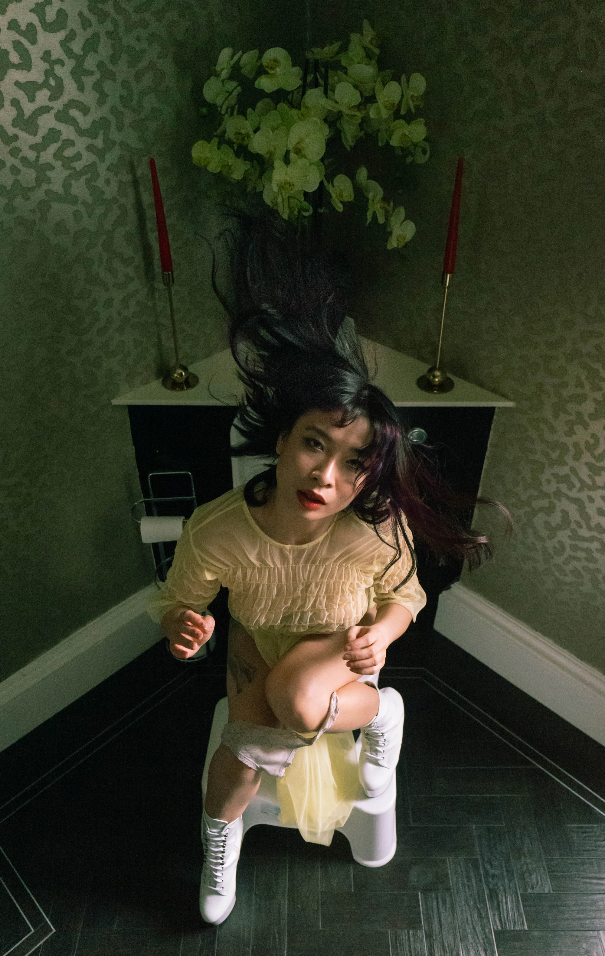 a woman on the toilet with a potty squatty.