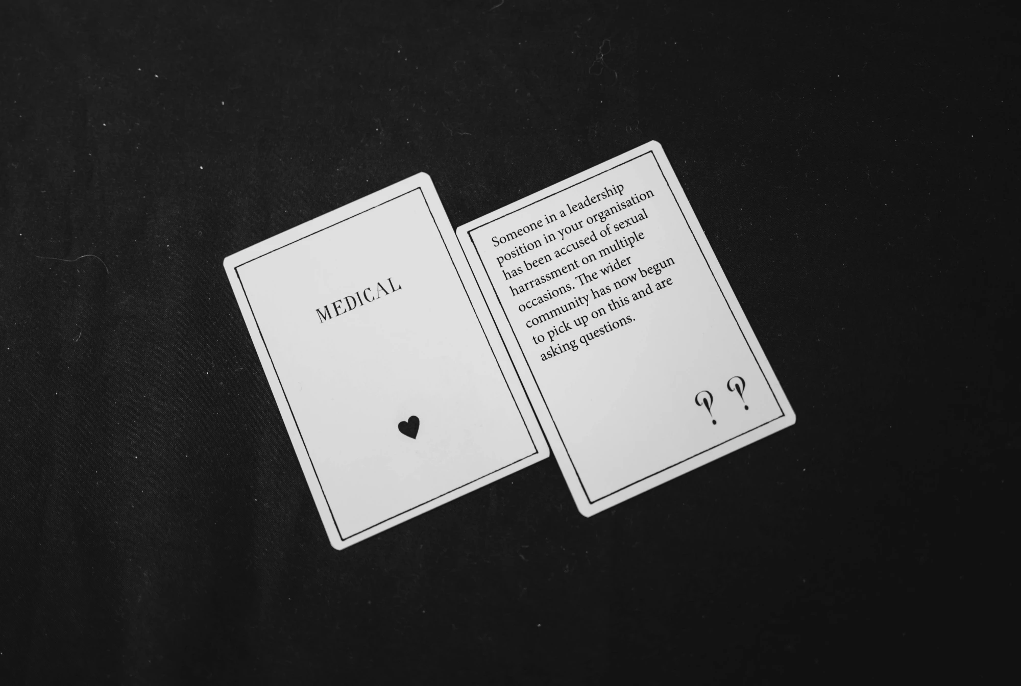 a close up of two cards on a black tablecloth.